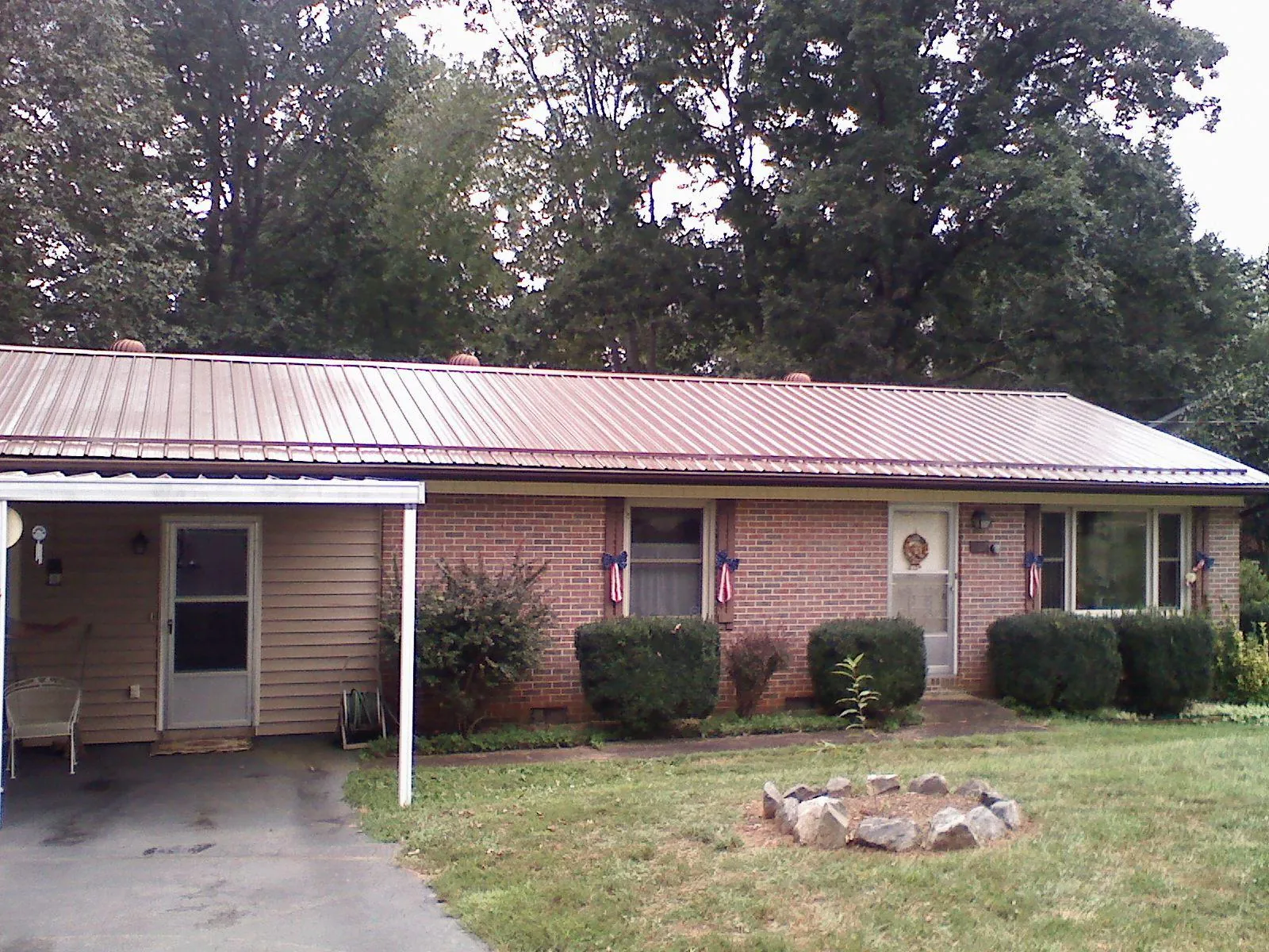 Bronze metal roof and carport on a brick ranch home — Roof Repair work by our crew in Flinton